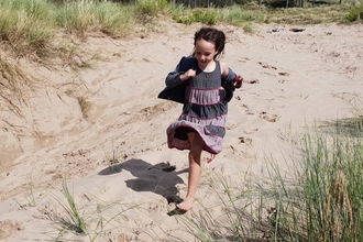 Girl running through sand dunes