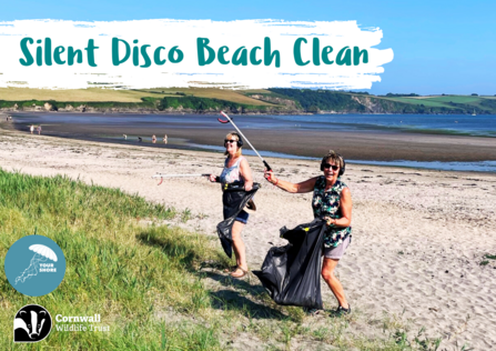 Two people litter picking on a beach with headphones on